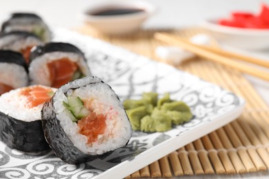 Tasty sushi rolls with wasabi served on table, closeup. Space for text
