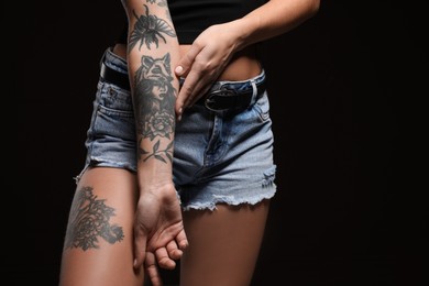 Woman with tattoos on body against black background. Space for text