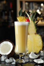 Tasty Pina Colada cocktail and ingredients on bar countertop