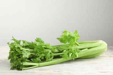 Fresh ripe green celery on white wooden table