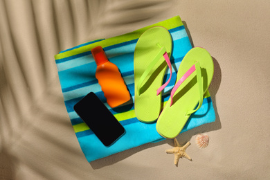 Photo of Flat lay composition with  smartphone and beach objects on sand
