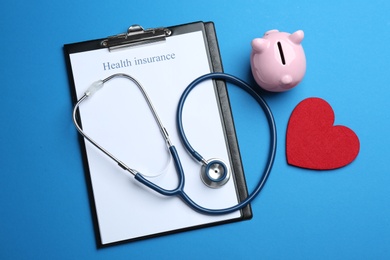 Flat lay composition with health insurance form and stethoscope on blue background