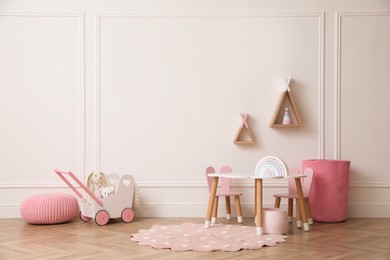 Cute child room interior with furniture, toys and wigwam shaped shelves on white wall