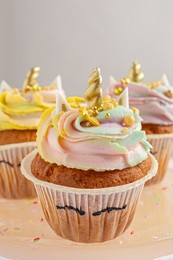 Photo of Dessert stand with cute sweet unicorn cupcakes plate, closeup