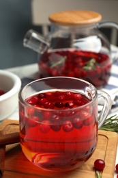 Tasty hot cranberry tea and fresh ingredients on table