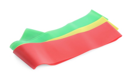 Photo of Set of red, green and yellow elastic resistance bands on white background. Fitness equipment