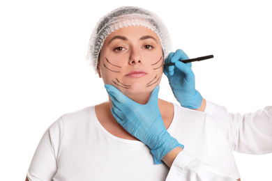 Doctor drawing marks on woman's face for cosmetic surgery operation against white background. Double chin problem