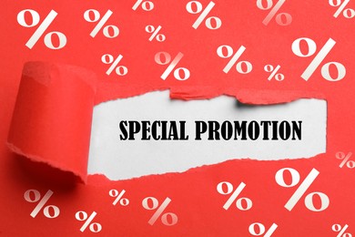 Phrase Special Promotion on white background through hole in red paper, top view