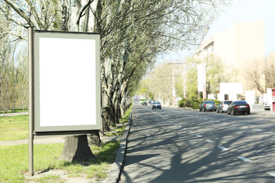Blank advertising board near road outdoors. Space for design
