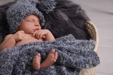 Adorable newborn baby lying in basket with faux fur