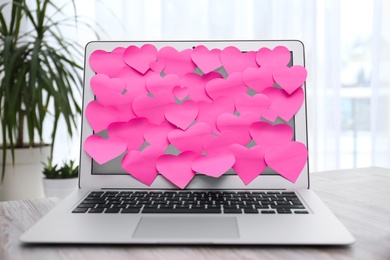 Heart shaped sticky notes on notebook at workplace. Valentine's Day celebration
