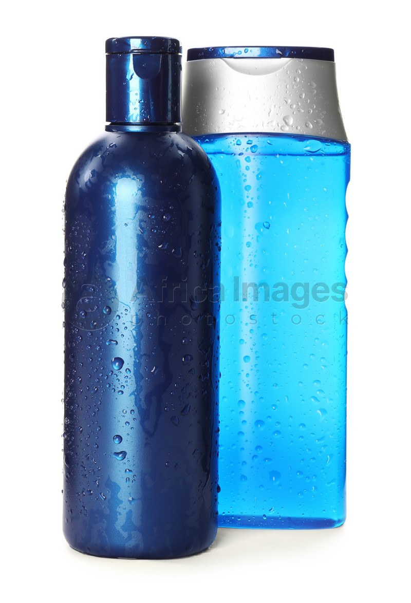 Photo of Blue bottles covered with water drops isolated on white. Men's cosmetics