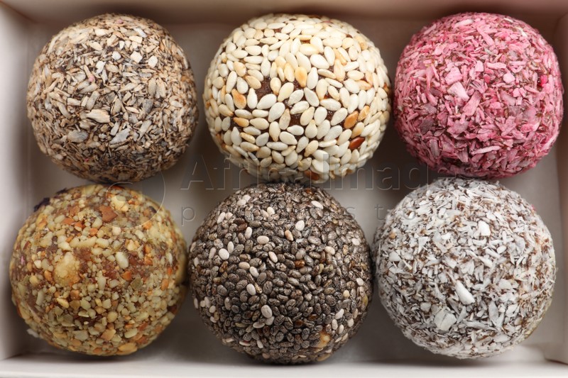 Different delicious vegan candy balls in box, top view