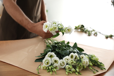 Florist making beautiful bouquet in workshop, closeup