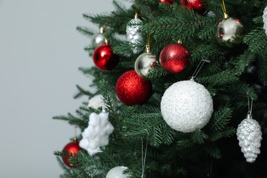 Beautifully decorated Christmas tree on grey background, closeup