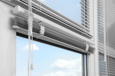 Window with horizontal blinds and control system indoors, closeup
