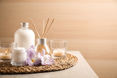 Photo of Composition with skin care products and reed air freshener on grey table, space for text