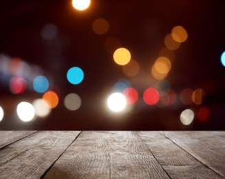 Empty wooden surface against blurred lights. Bokeh effect 