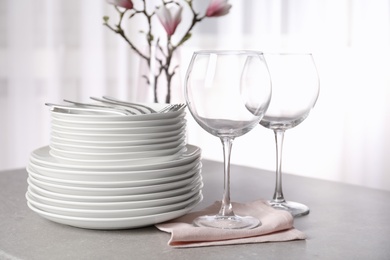 Set of clean dishes on table against blurred background