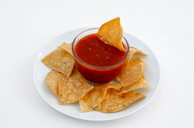 Photo of Tasty salsa sauce and tortilla chips on white background