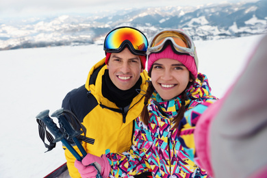 Happy couple taking selfie at ski resort. Winter vacation