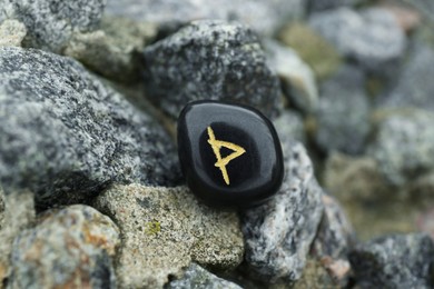 Photo of Black rune Wunjo on stones outdoors, closeup