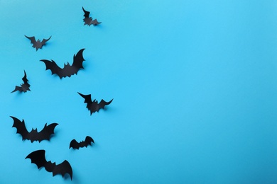 Paper bats on light blue background, flat lay with space for text. Halloween decor