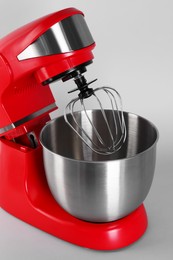 Photo of Modern red stand mixer on light gray background