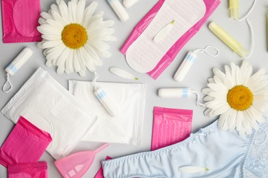 Tampons and other menstrual hygienic products on grey background, flat lay