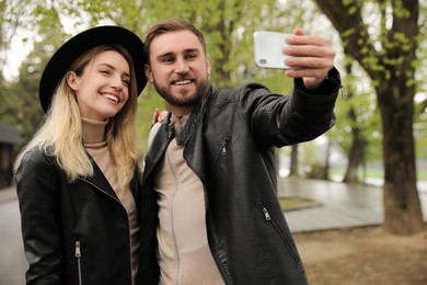 Lovely couple with smartphone taking selfie on spring day