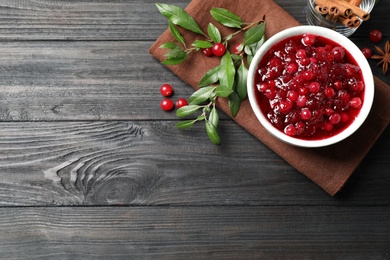 Flat lay composition with cranberry sauce on grey wooden table, space for text
