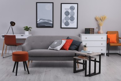 Stylish grey living room interior with comfortable sofa