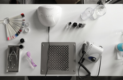 Photo of Professional equipment for manicure on table in beauty salon, top view