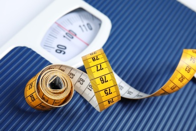 Scales with tape measure, closeup view. Diet and weight loss