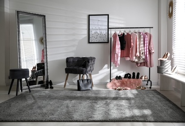 Dressing room interior with clothing rack and comfortable chair
