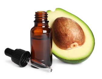 Cut avocado, bottle of essential oil and pipette on white background