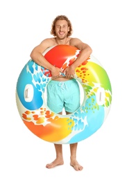 Attractive young man in swimwear with colorful inflatable ring on white background