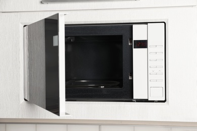 Photo of Open modern microwave oven built in kitchen furniture