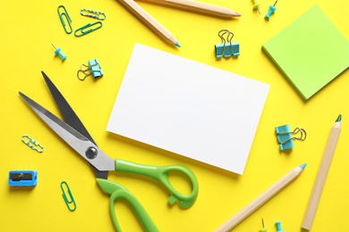 Flat lay composition with scissors and office supplies on color background. Space for text