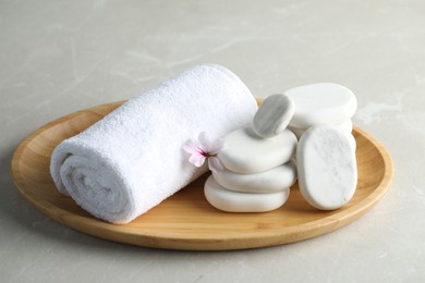Photo of Spa stones, towel and fresia flower on light table
