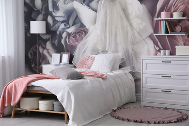 Teenage girl's room interior with comfortable bed and floral wallpaper. Idea for stylish design