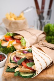 Photo of Delicious shawarma with chicken and fresh vegetables on table, closeup
