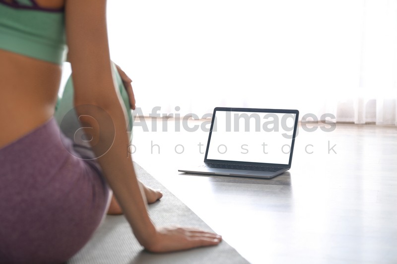 Woman having online video class via laptop at home, closeup. Distance yoga course during coronavirus pandemic