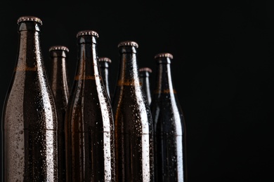 Photo of Bottles of beer on black background, closeup. Space for text