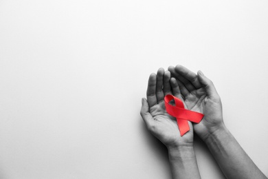 World AIDS disease day. Woman holding red awareness ribbon on white background, top view with space for text