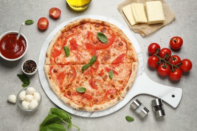 Photo of Delicious pizza Margherita and ingredients on light grey table, flat lay