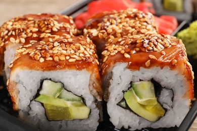 Box with tasty sushi rolls, closeup. Food delivery service