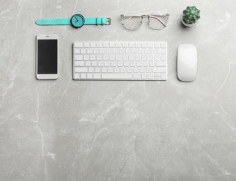 Photo of Flat lay composition with smartphone, keyboard and space for text on grey background. Blogger's workplace