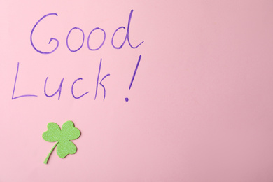 Phrase GOOD LUCK and clover leaf on pink background, top view. Space for text