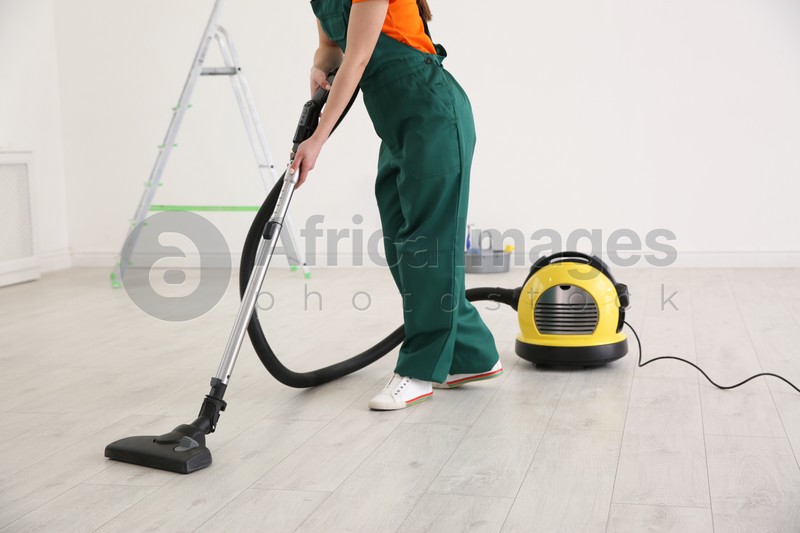 Professional young janitor vacuuming indoors. Cleaning service